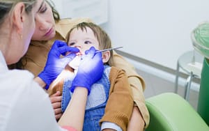A child undergoes a dental examination to assess and address the risks associated with tooth decay.