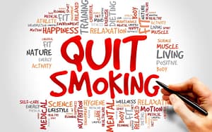Hand writing "quitting smoking" on white background, promoting dental health.