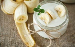 A jar of yogurt with bananas, providing relief for braces pain.