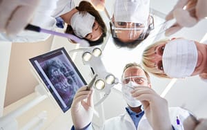 A group of dentists discussing how to handle a dental emergency while travelling.