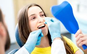 A woman is receiving dental care from a dentist.