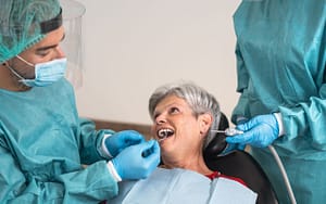An older woman undergoes a dental examination for root canal treatment.